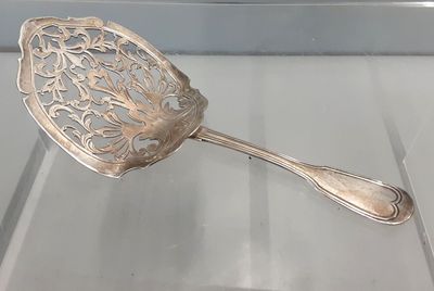 une cuillère en argent posée sur une table en verre