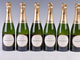 six bottles of champagne are lined up in a row