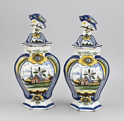 deux vases bleus et blancs surmontés d'un oiseau