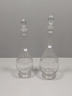 une paire de carafes en verre transparent posées sur une table blanche