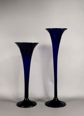 une paire de vases en verre bleu posés sur une table blanche