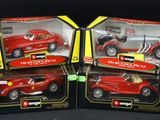 two red toy cars are in a box on a black surface