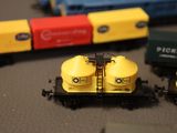 a toy train on the table next to other toy trains