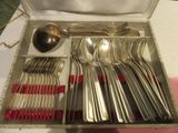 une boîte contenant des couverts et des cuillères posée sur une table