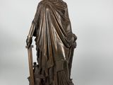 a bronze statue of a woman holding a sword and shield