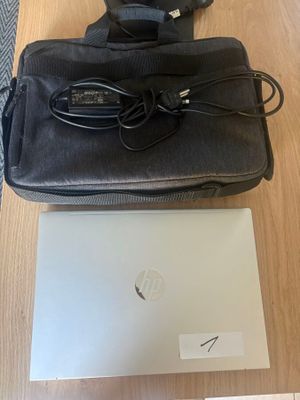 un ordinateur portable et un sac posés l'un à côté de l'autre sur une table