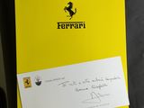le logo Ferrari sur un dossier jaune auquel est attachée une note