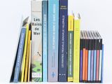 several books are stacked on top of each other on a white surface