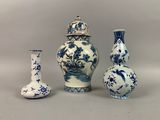 trois vases bleus et blancs sont alignés sur un fond gris