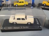 four different model cars are in a display case on a table