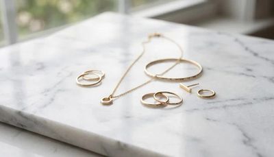 un plan de travail en marbre sur lequel sont posés des bijoux en or