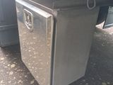 a metal box sitting on the ground next to a truck