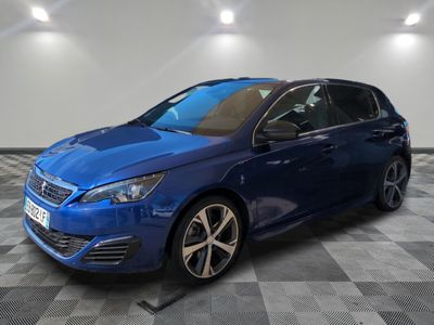 une voiture bleue garée dans un garage au sol en damier