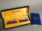 two pens and a notebook in a box on a table