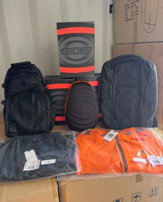 many bags of luggage sitting on top of a cardboard box