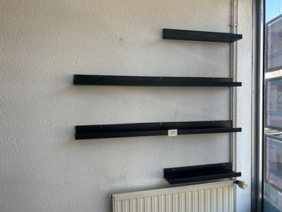 a radiator in front of a window with shelves on the wall
