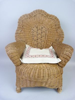 a wicker chair with a pillow on top of it