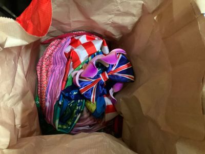 un sac en papier brun contenant tout un tas d'objets de différentes couleurs