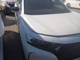 a white car parked in a parking lot with other cars