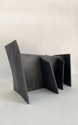 une image représentant une chaise noire posée sur un sol blanc