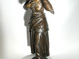 bronze statue of a woman holding her hand up to her ear