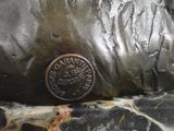 a bronze statue of a dog with a coin on it