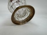 a glass jar with a gold lid on a white surface