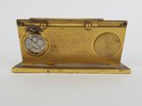 an image of a gold clock on a stand on a white surface