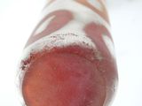 a close up view of a red and white striped ice lolly