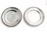 paire de plats plaqués argent sur un support blanc avec un fond blanc