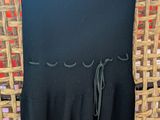 the black dress is hanging on a wicker chair in the room