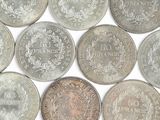 six different types of coins are arranged on a white surface