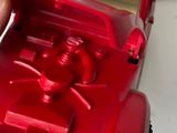 a close up of a red toy truck with a person holding it