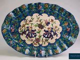 une assiette bleue et blanche ornée de fleurs et d'oiseaux