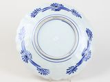 blue and white plate with a gold rim on a stand