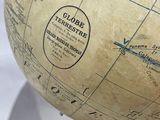 a small globe on a wooden stand with a white background