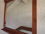 a mirror hanging on the wall above a bed