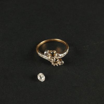 une bague en or et diamants, ornée de deux diamants sur un fond noir