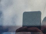 reflection of a man taking a picture of himself in a car window