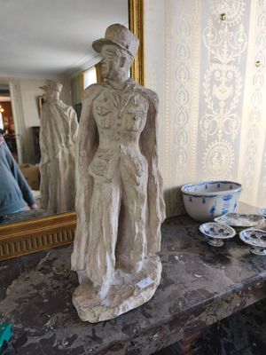 une statue représentant un homme debout sur une table, à côté d'un miroir