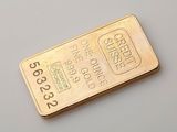 gros plan d'un lingot d'or sur une surface blanche