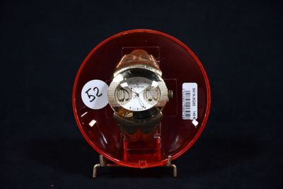 une montre dans un étui rouge, avec une étiquette de prix dessus