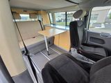 the interior of a camper van with a table and chairs