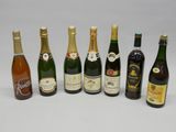 plusieurs bouteilles de vin sont alignées sur une surface blanche