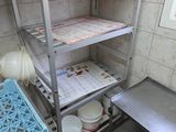 une étagère métallique sur laquelle sont posées des assiettes et des bols, dans une cuisine