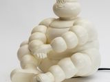 une figurine blanche représentant un homme assis par terre