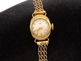 an image of a woman ' s wrist watch with a chain around it