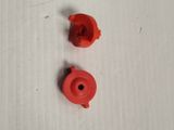 two pieces of red plastic sitting on a white surface