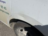 a white truck with a flat tire parked on the side of the road