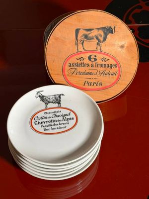 a stack of plates sitting on a table with a cow on it